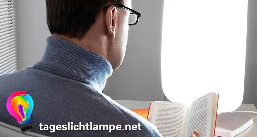 Tageslichtlampe im Einsatz - Mann sitzt mit Buch vor einer Tageslichtlampe